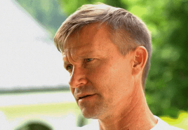 a close up of a man 's face with a green background