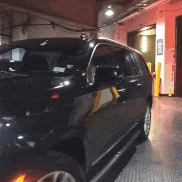 a black car is parked in a garage with a sign that says tc 1