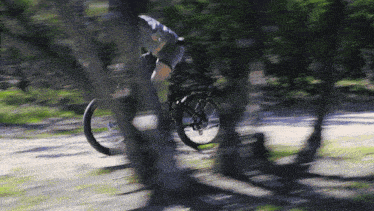 a blurry picture of a person riding a bike on a trail