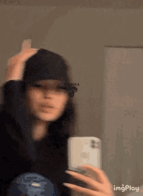 a girl is taking a selfie in front of a mirror .