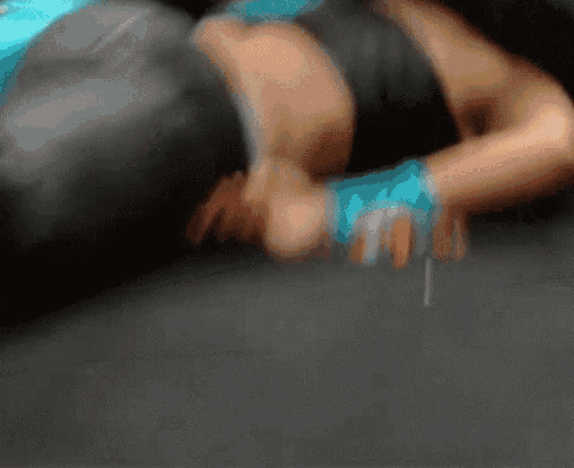 a blurry picture of a person laying on the floor with a boxing glove on their hand .