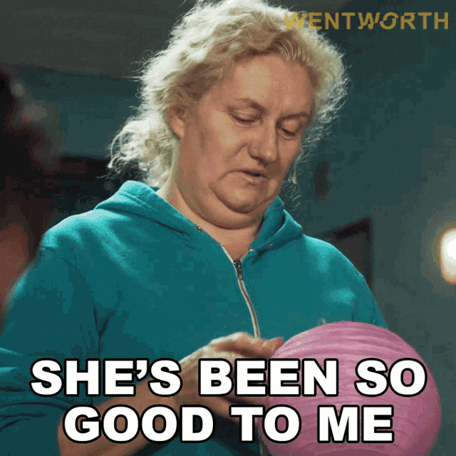 a woman in a blue hoodie is holding a pink ball and says she 's been so good to me