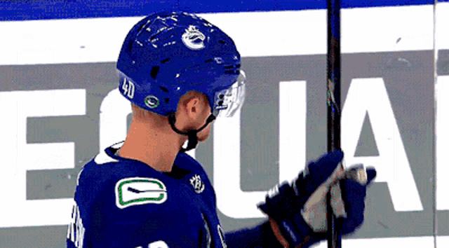 a hockey player wearing a blue helmet with the letter e on it