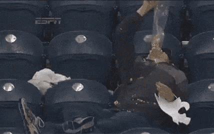 a man is laying in a stadium seat with espn written on the back