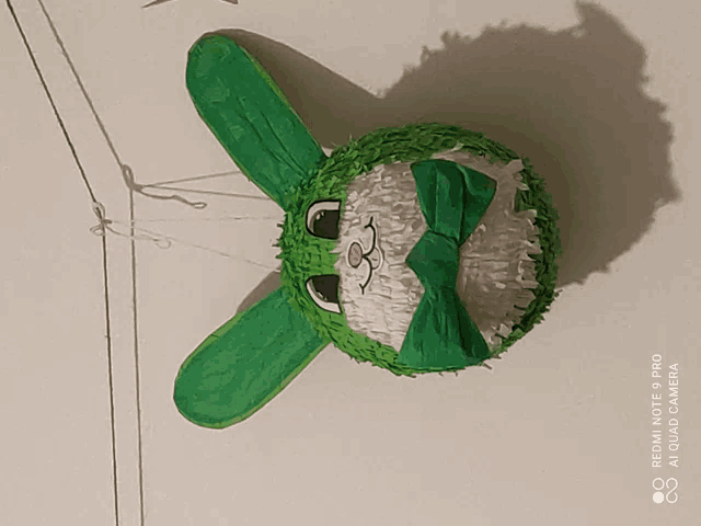 a green and white bunny piñata with a bow
