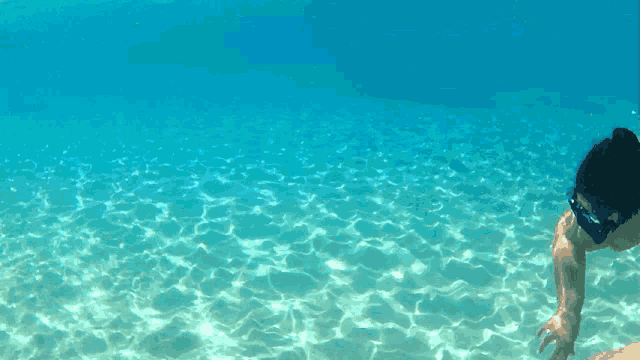 a person wearing a mask is swimming in the water
