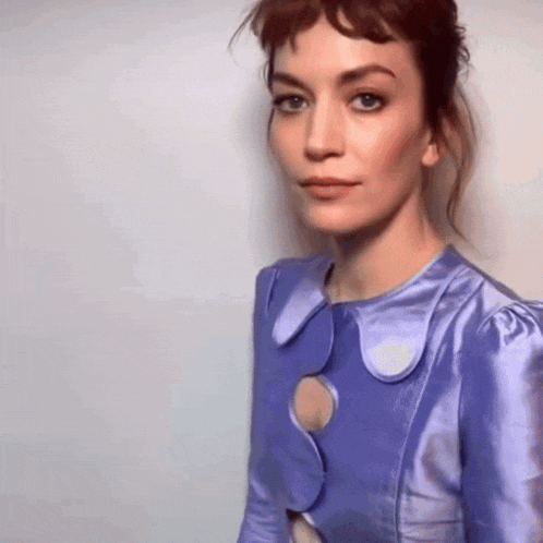 a woman is wearing a purple dress with a hole in the middle