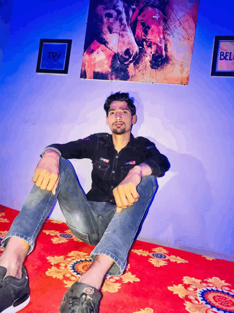 a man is sitting on the floor in front of a painting that says try
