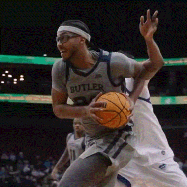 a basketball player wearing a butler jersey is dribbling the ball
