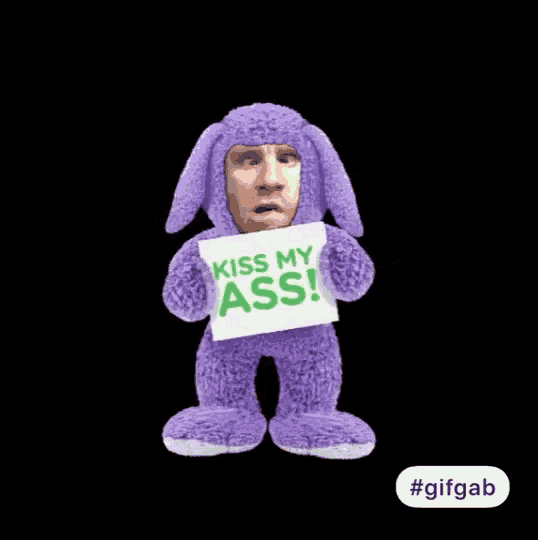a purple stuffed animal holding a sign that says " kiss my ass "