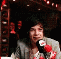 a man in a suit is talking into a microphone