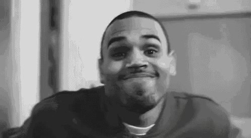 a black and white photo of a man with a beard making a funny face .