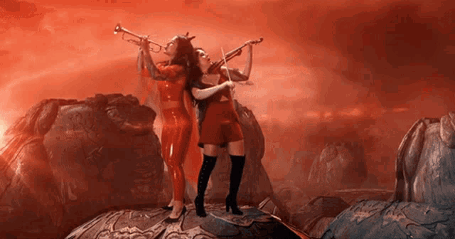 two women in red playing violins and trumpets in a red background
