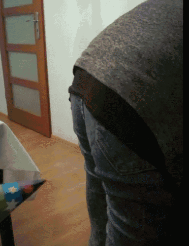 a person standing in front of a door with a gray shirt on