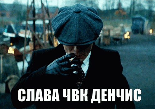 a man in a suit and hat smoking a cigarette with the words " slava cbk denhic " on the bottom