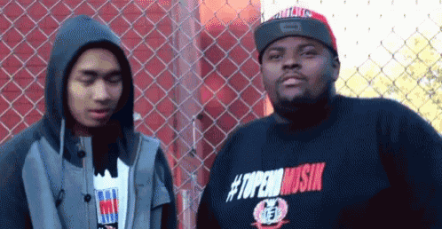 two men standing next to each other one wearing a shirt that says #topenmusik on it
