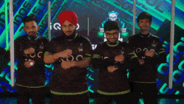 a group of men are posing for a picture and one of them has a turban on his head