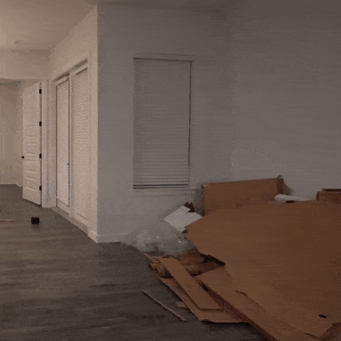 a person standing in a room with a pile of cardboard on the floor