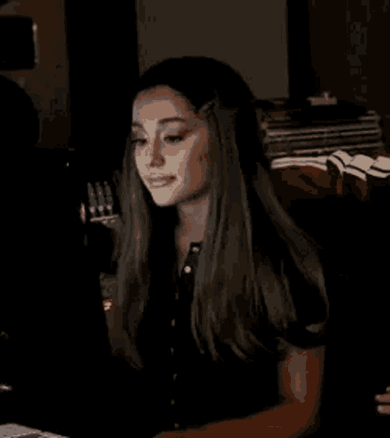 ariana grande is sitting in front of a laptop computer .