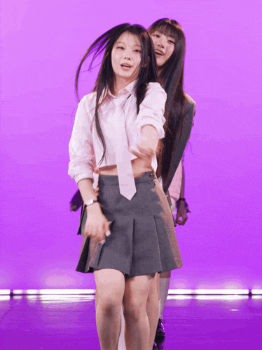 two girls are dancing on a stage and one has a watch on her wrist