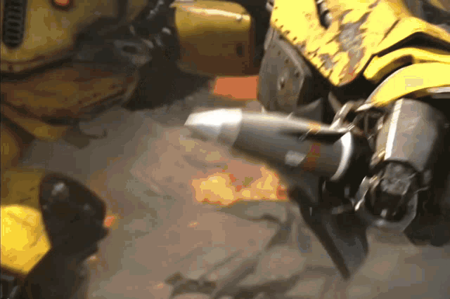 a close up of a yellow robot with a rocket coming out of it 's mouth