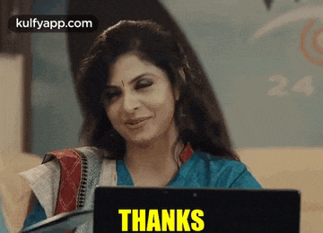 a woman is sitting in front of a laptop with the words thanks written on it