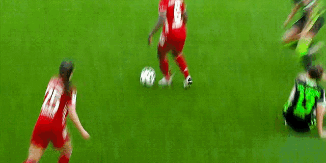 a blurry picture of two soccer players on a field with one wearing number 20