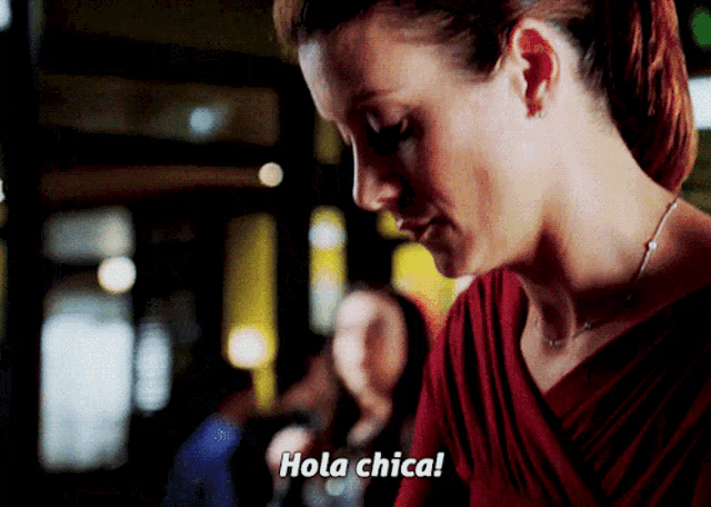 a woman in a red dress is saying hola chica in spanish