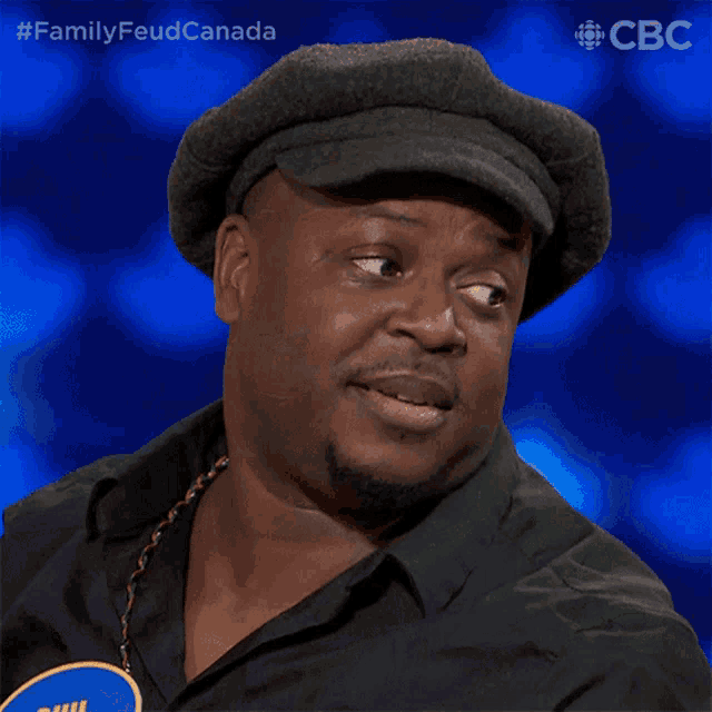 a man wearing a hat with the words family feud canada on the bottom right