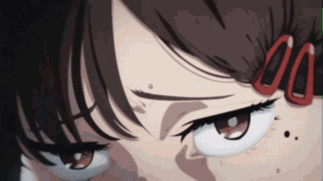 a close up of a girl 's eyes with red glasses on her head