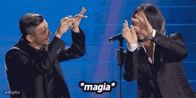 two men giving each other a high five with the word magia in the upper right corner
