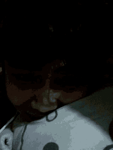 a person is laying on a bed with their eyes closed and their mouth open .