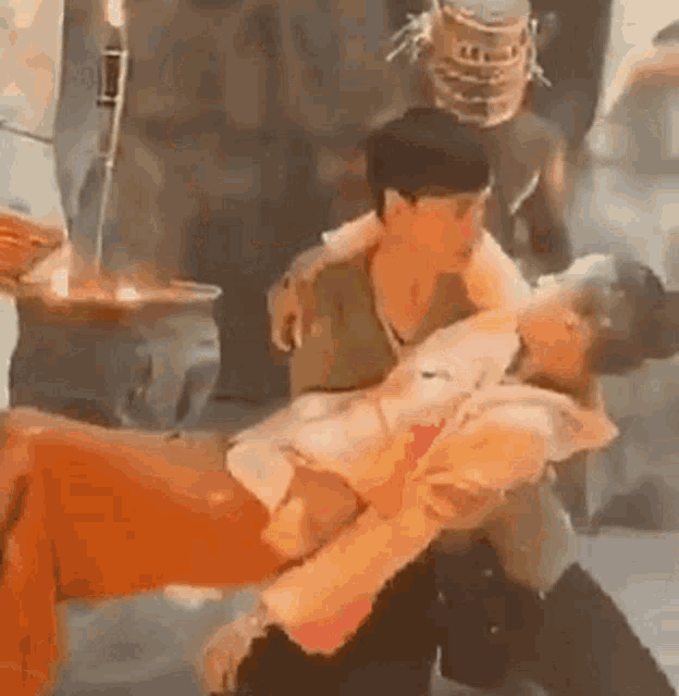 a man is carrying a woman in his arms in a room .