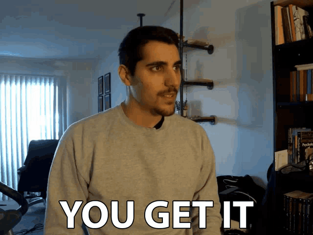 a man wearing a grey sweater says you get it