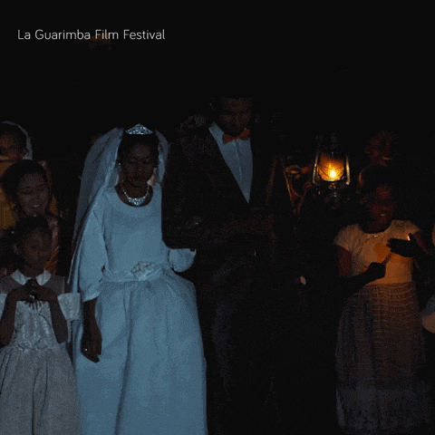 a bride and groom are walking through a dark room with the words la guarimba film festival above them