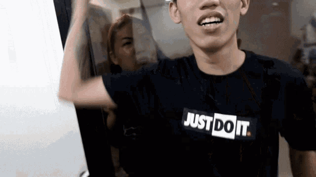 a man wearing a black just do it shirt