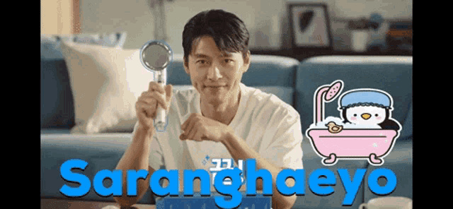 a man is holding a shower head in front of a bathtub with a penguin in it
