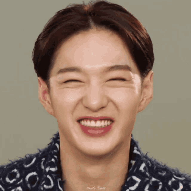 a close up of a man 's face with his eyes closed smiling