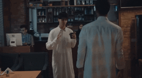 a man in a white shirt is standing next to another man