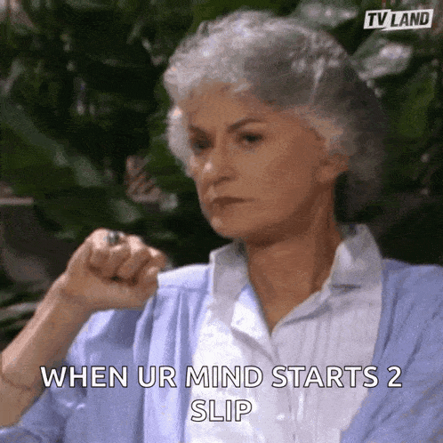 a woman with gray hair is sitting in front of a plant and says `` when ur mind starts 2 slip ''