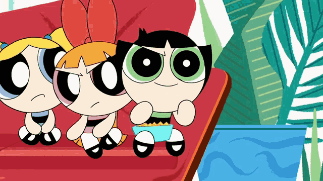 the powerpuff girls are sitting on a couch and buttercup is holding a cup of popcorn