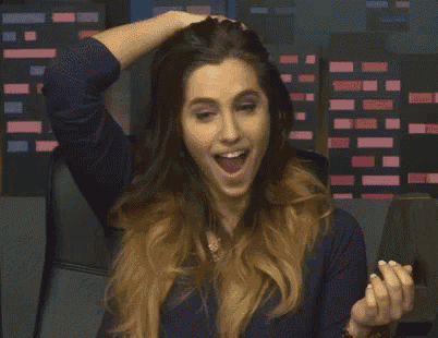 a woman with her mouth open is holding her hair