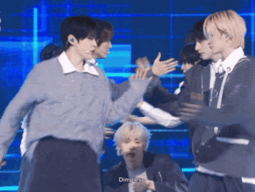 a group of young men are dancing on a stage and one of them says " dimples " on the bottom