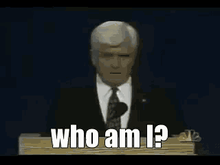 a man in a suit and tie stands at a podium and says why am i here ?