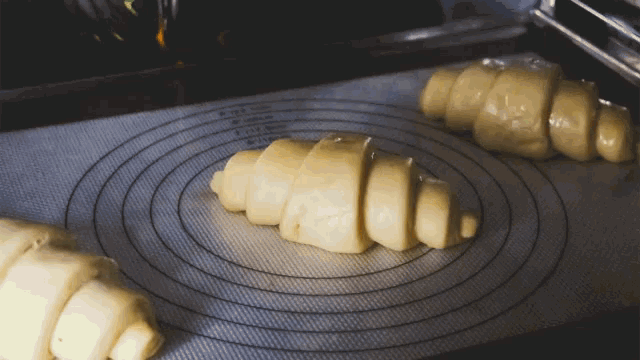 two rolls of dough are sitting on a silicone mat that says ' silicone ' on it