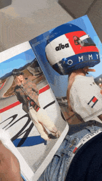 a person is holding a helmet that says tommy on it