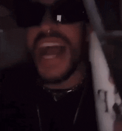 a close up of a man wearing sunglasses and a nose ring