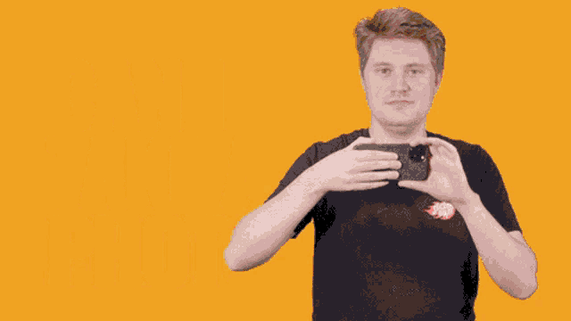 a man holding a cell phone with the words can i take a photo behind him