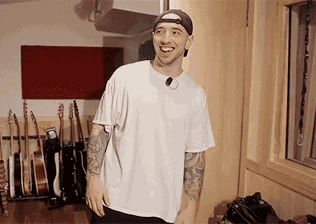 a man wearing a white shirt and a hat is smiling