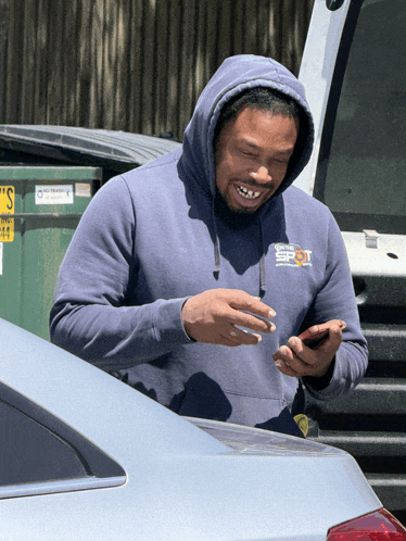 a man wearing a blue sweatshirt with the word spot on the front